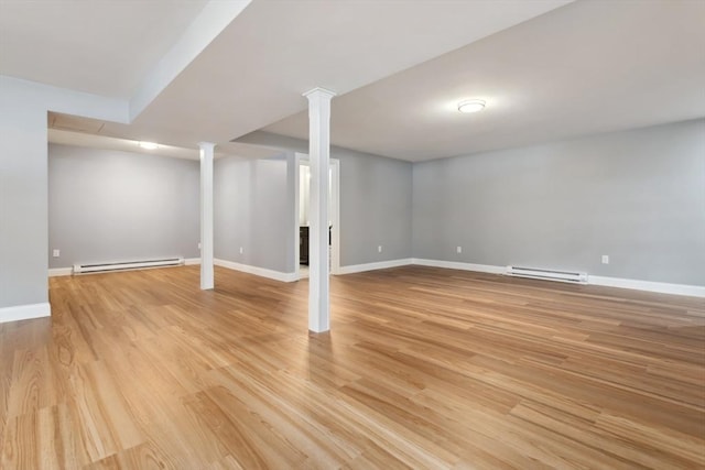 finished basement with baseboards, light wood-style flooring, and baseboard heating