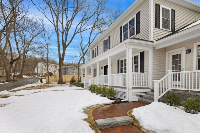 view of snow covered exterior featuring covered porch