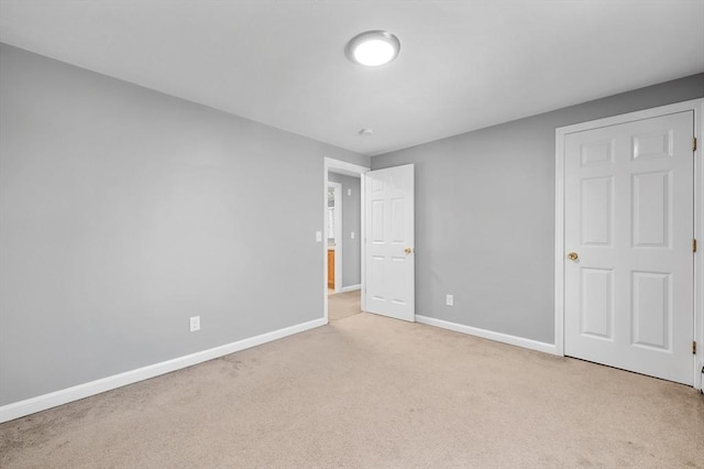 unfurnished bedroom with baseboards and carpet
