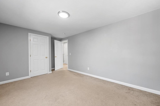 unfurnished bedroom featuring baseboards and light colored carpet