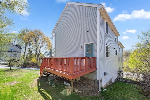 rear view of house with a lawn and a wooden deck