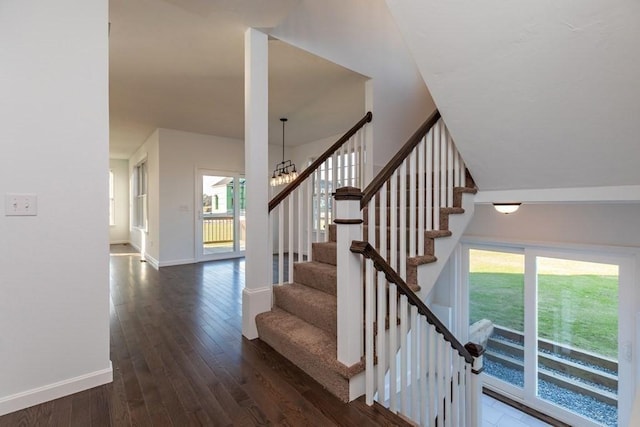 stairway featuring hardwood / wood-style floors and a chandelier