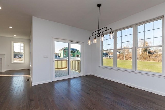 unfurnished dining area with dark wood-type flooring