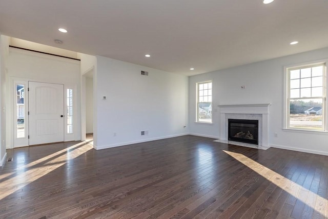 unfurnished living room with dark hardwood / wood-style flooring and a high end fireplace