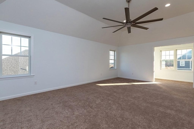 carpeted empty room with ceiling fan, a healthy amount of sunlight, and lofted ceiling