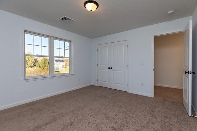 unfurnished bedroom featuring carpet and a closet