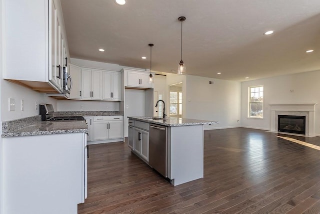 kitchen featuring white cabinetry, sink, stainless steel dishwasher, pendant lighting, and a kitchen island with sink