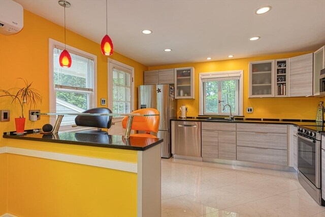 kitchen with stainless steel appliances, dark countertops, a wall mounted air conditioner, recessed lighting, and a sink
