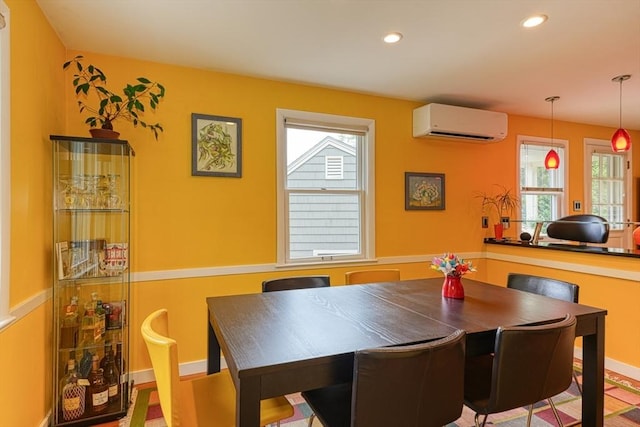 dining room with an AC wall unit, recessed lighting, and healthy amount of natural light