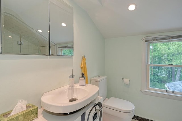 bathroom with toilet, vaulted ceiling, a tile shower, and recessed lighting