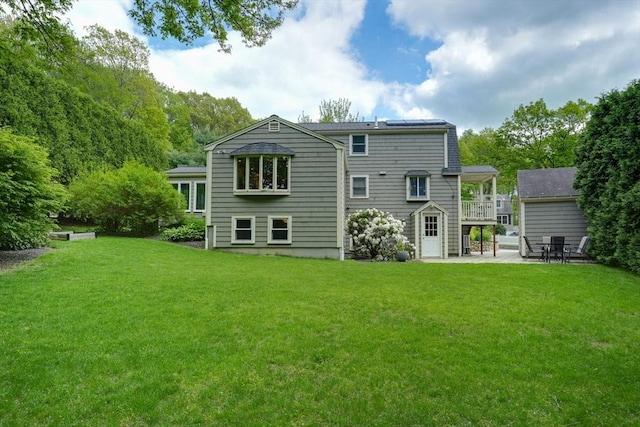back of house featuring a patio and a lawn