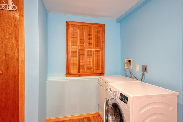 clothes washing area featuring independent washer and dryer and wood finished floors