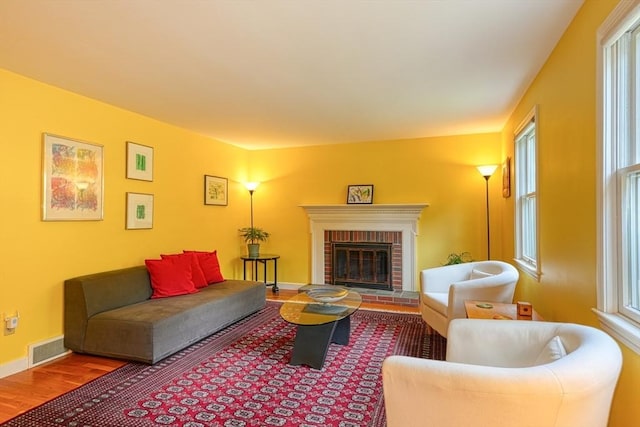 living area with wood finished floors, healthy amount of natural light, a fireplace, and baseboards