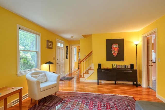 living area featuring wood finished floors, stairs, and baseboards