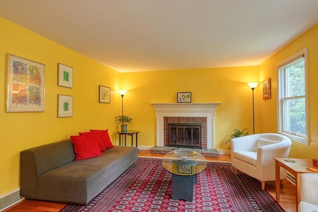 living room featuring wood finished floors and a brick fireplace