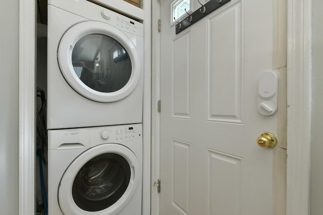 washroom with stacked washer and dryer and laundry area