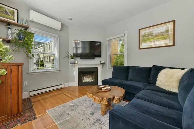 living room featuring a baseboard radiator, wood finished floors, plenty of natural light, and a wall mounted AC