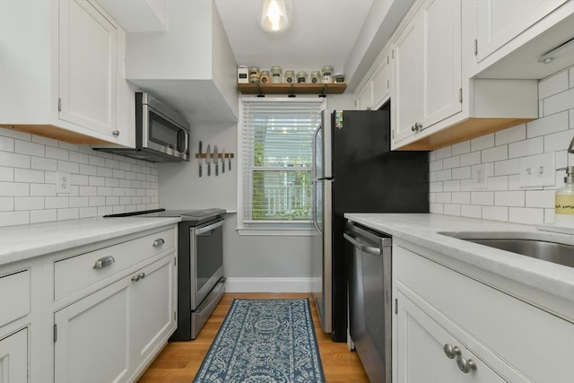 kitchen featuring light wood-style floors, white cabinetry, and appliances with stainless steel finishes