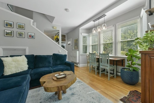 living area featuring baseboards, wood finished floors, and a notable chandelier