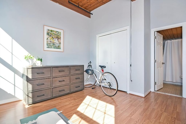 interior space with light wood finished floors, wooden ceiling, and a high ceiling