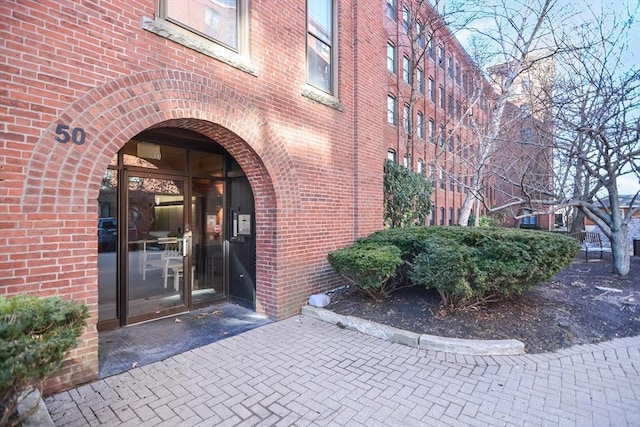 entrance to property featuring brick siding