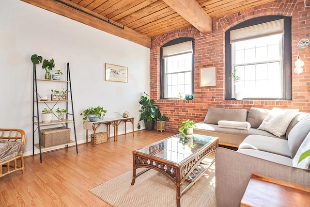 living room featuring beamed ceiling, brick wall, wood ceiling, and light wood finished floors