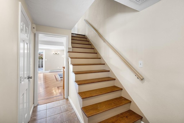 stairs featuring tile patterned floors and a baseboard heating unit