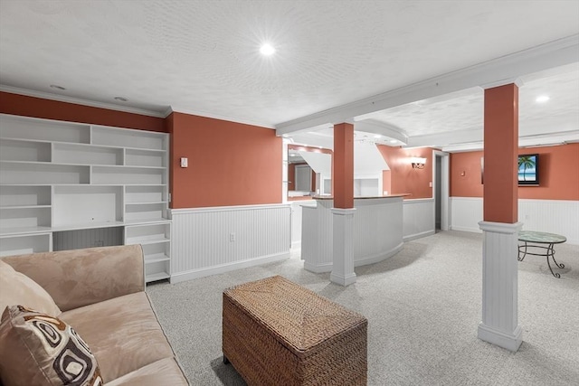 carpeted living room featuring crown molding, decorative columns, and a textured ceiling