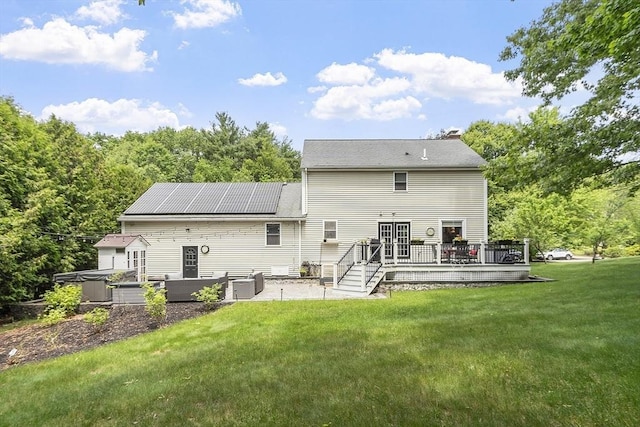 51 Carrie Ann Ln, Fitchburg, MA 01420 - back of property featuring a deck, a patio, a yard, and roof mounted solar panels