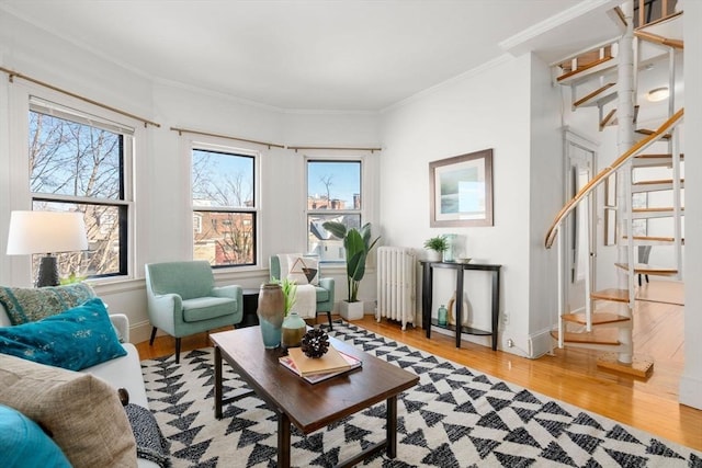 sitting room featuring radiator, ornamental molding, and hardwood / wood-style flooring