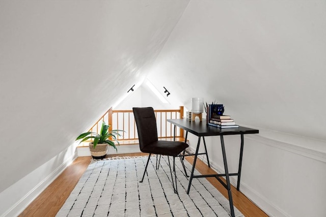 home office with light wood-type flooring and lofted ceiling