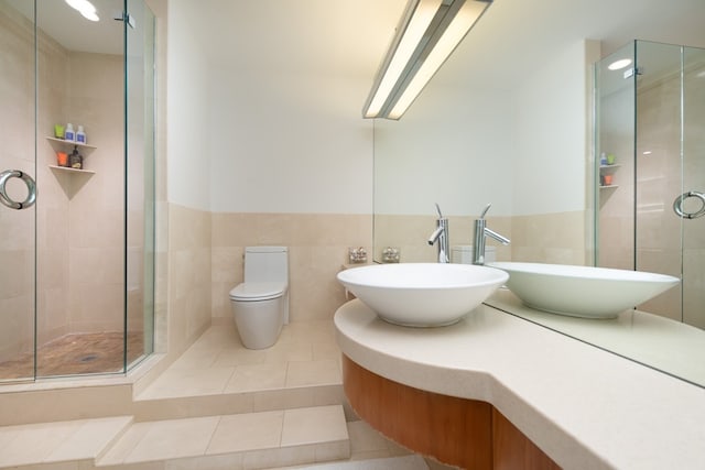 bathroom with toilet, an enclosed shower, and tile patterned floors