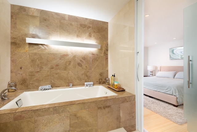 bathroom featuring tile walls and a relaxing tiled tub