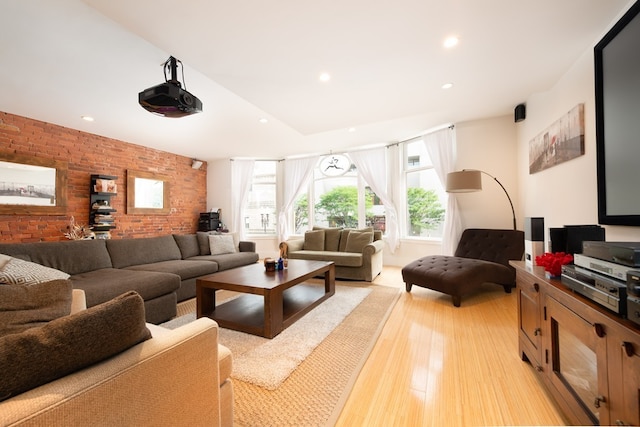 cinema featuring light hardwood / wood-style floors and brick wall