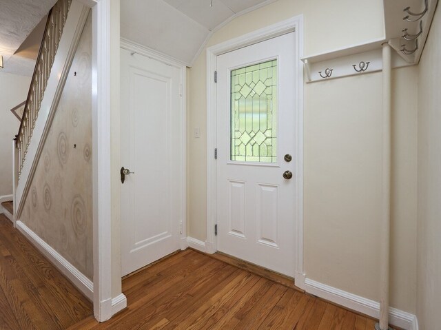 doorway to outside with hardwood / wood-style floors and lofted ceiling