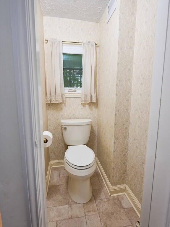 bathroom with toilet and tile patterned floors