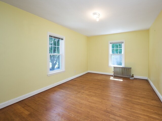 empty room with radiator and hardwood / wood-style floors