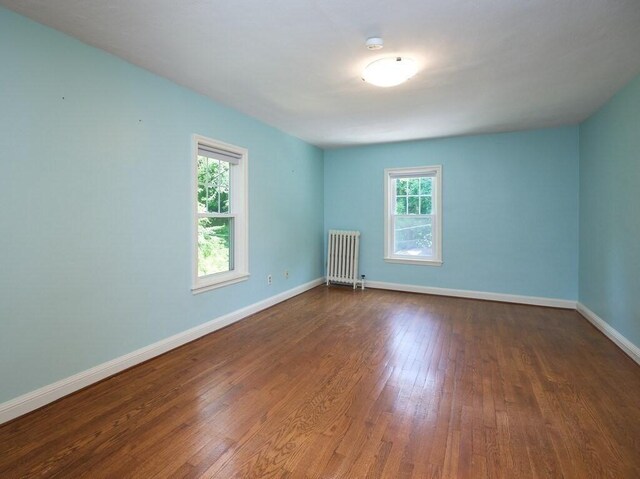 unfurnished room with wood-type flooring and radiator