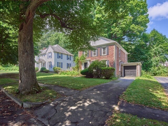 colonial inspired home featuring a front yard and a garage