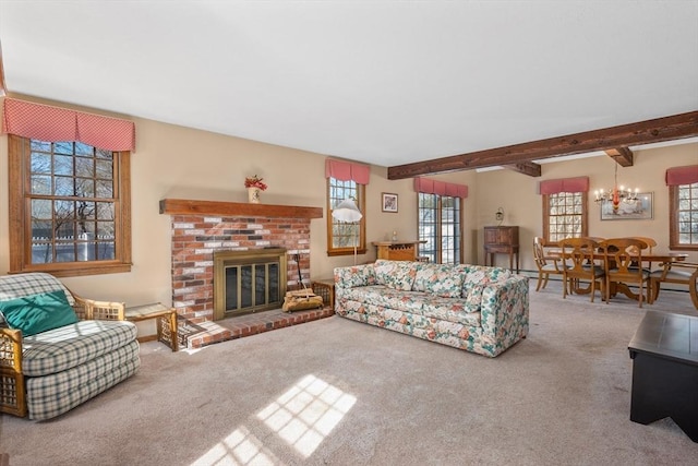 carpeted living room with a fireplace, beamed ceiling, and an inviting chandelier