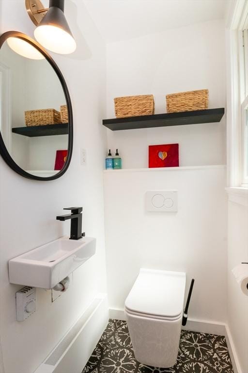 bathroom featuring tile patterned flooring, a sink, baseboards, and toilet