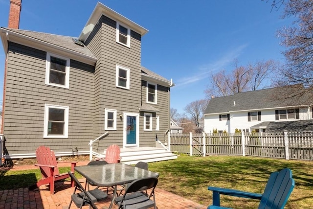 back of property with fence, a patio, a chimney, a yard, and outdoor dining space