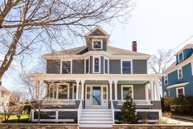 view of front facade featuring covered porch and a chimney