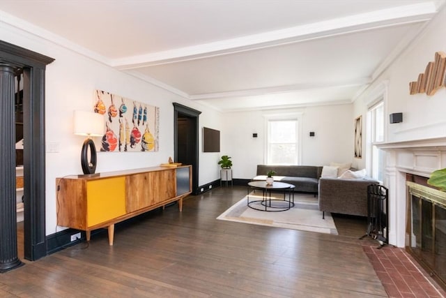 living area featuring dark wood-type flooring, a fireplace with flush hearth, ornamental molding, and beamed ceiling