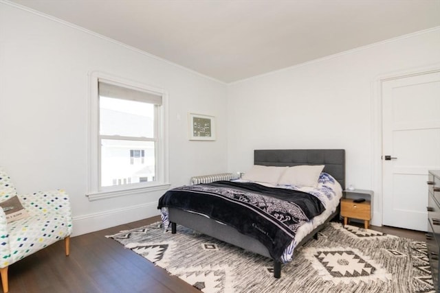 bedroom with crown molding, baseboards, and wood finished floors