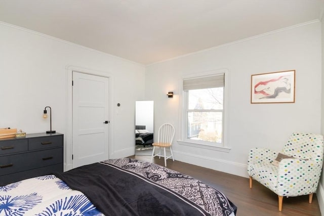 bedroom with crown molding, baseboards, and dark wood finished floors
