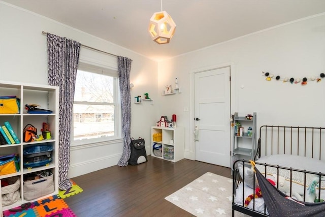 bedroom featuring baseboards, ornamental molding, and wood finished floors