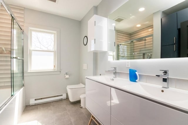 full bath with double vanity, toilet, a sink, and baseboard heating
