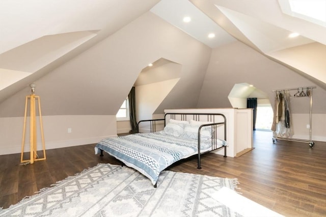 bedroom featuring wood finished floors, vaulted ceiling, and multiple windows