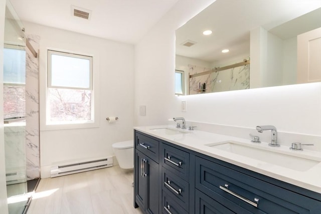 bathroom with visible vents, a sink, a marble finish shower, and baseboard heating